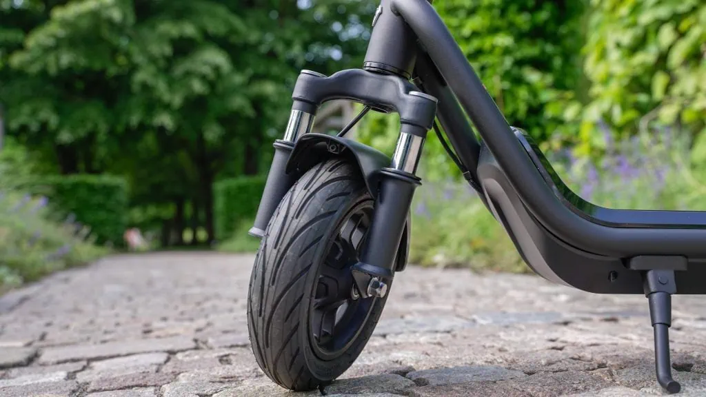 NIU KQi 100F Review: Exceptional Comfort and Portability Under $500 16 Closeup of the front tire and fork suspension on NIU KQi 100F