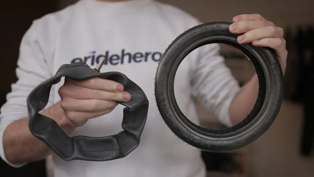 Buying Guide: How To Choose an Electric Scooter 7 Man holding a pneumatic inner tube tire for an electric scooter wearing an ERideHero shirt