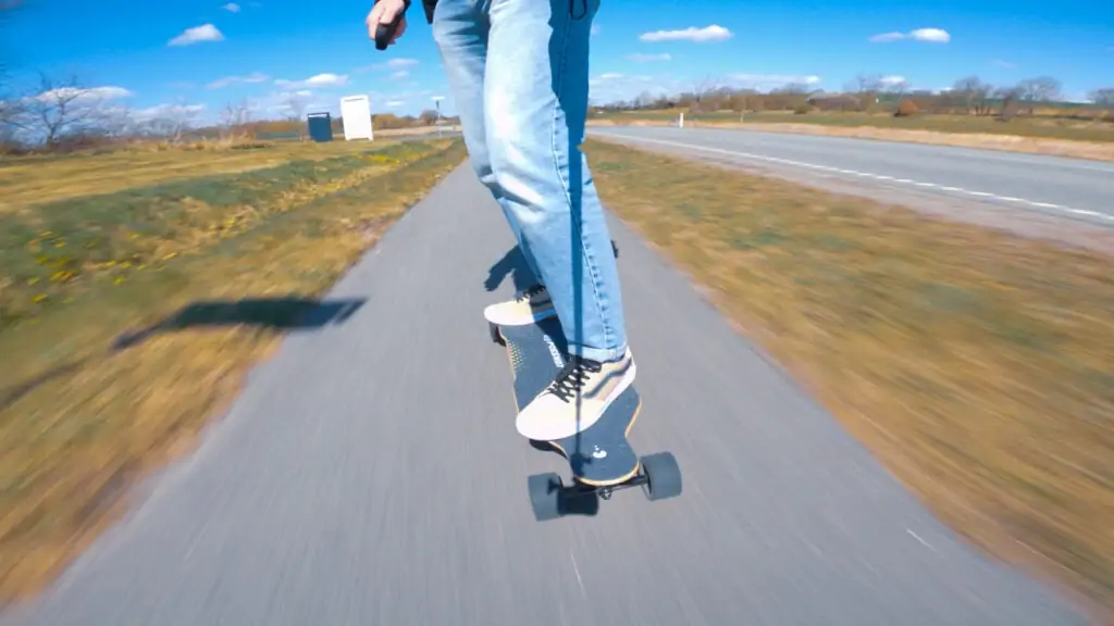 man riding a possway t2 electric skateboard on a bicycle path on a sunny day