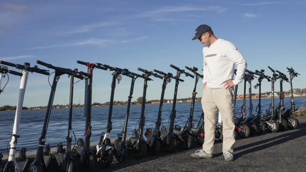 Rasmus from ERideHero with a lineup of over 20 electric scooter near the ocean